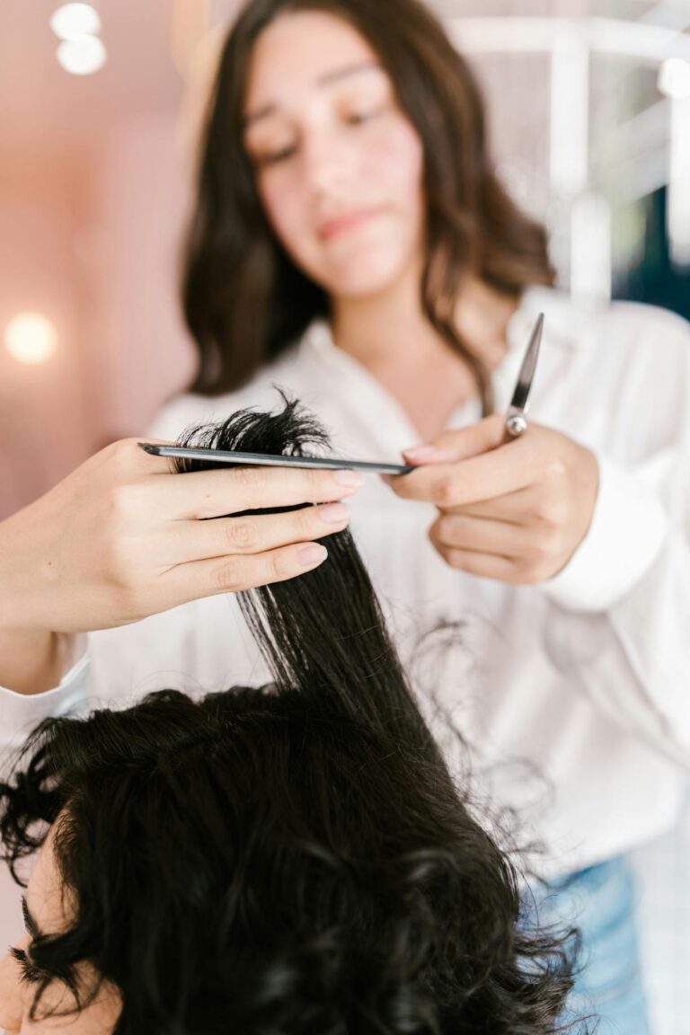 Close-up of hairstylist expertly cutting client’s hair in a salon setting.