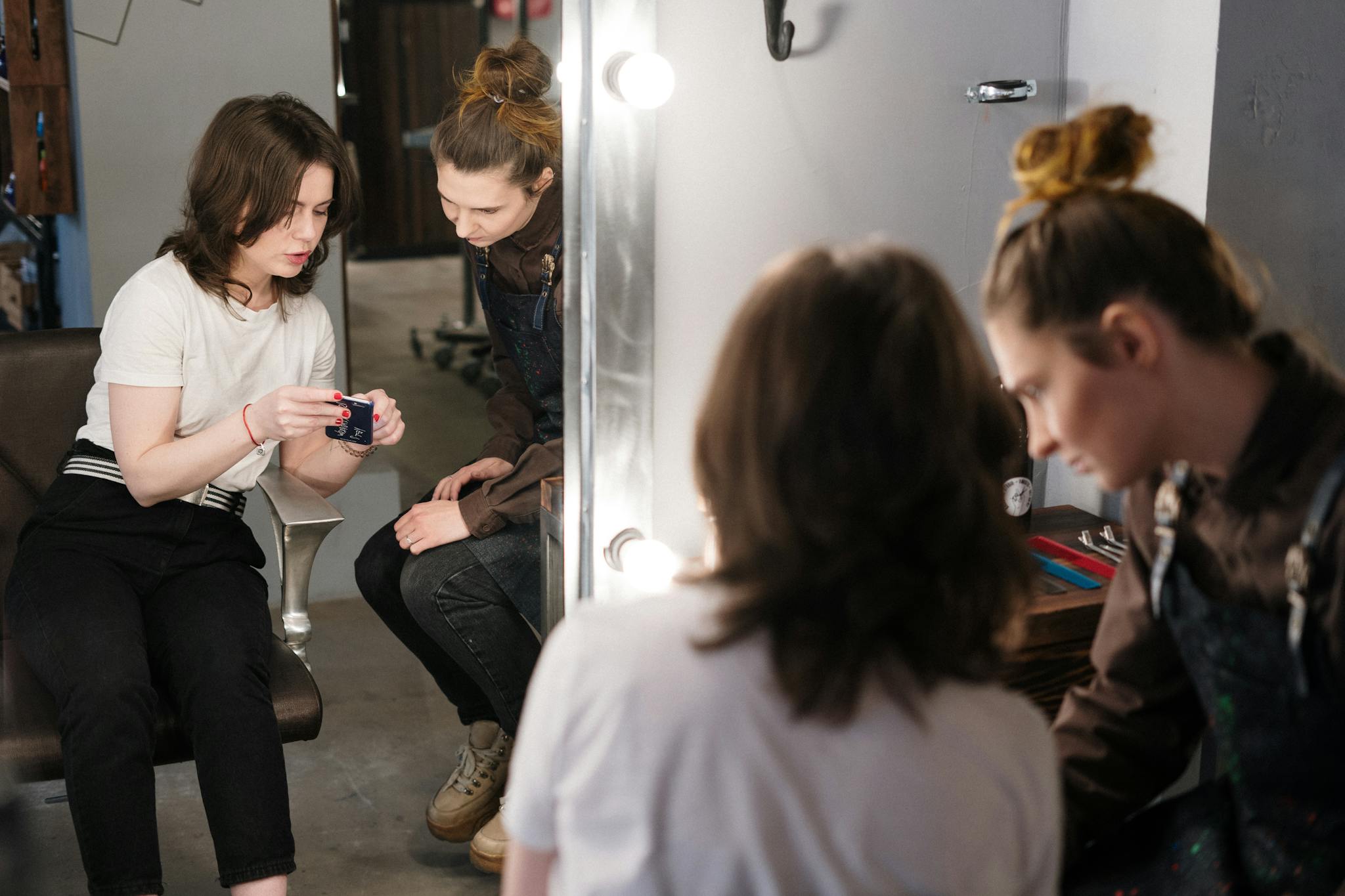 Two women engaged in a hair consultation at a salon, reflecting professionalism and style.